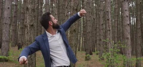 Bearded man in pine forest, throws pine cone Video stock 140265492