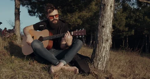 A bearded man is playing at the guitar Stock Footage 134573978