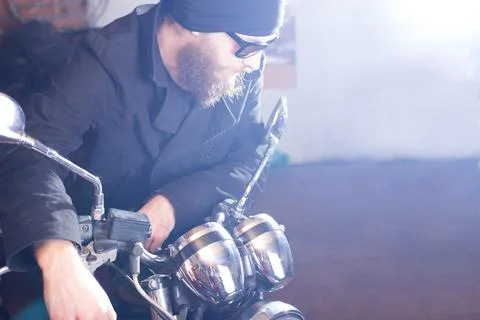 Bearded man posing with his shiny stylish chopper. Stock Photos
