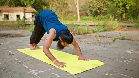 Bearded man practices pushups on a mat outdoor Stock Footage 303965566