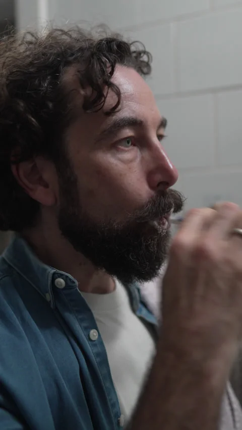 Bearded man practicing daily dental hygiene routine Stock Footage 336624671