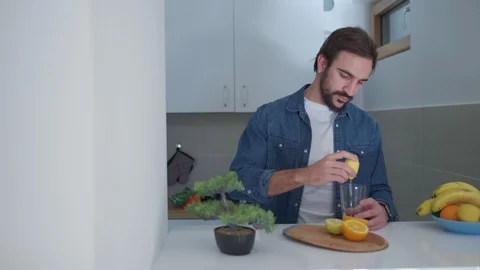 Bearded man preparing fresh fruit juice in the kitchen Stock-Footage 127648938