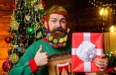 Bearded man with present gift box showing thumb up. Wish you merry Christma.. Stock Photos
