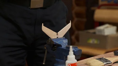 Bearded man puts elevator on wooden tail unit planes model Stock Footage 127375321