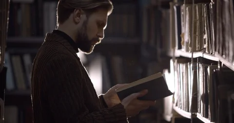 Bearded Man Reading Dusty Book in Library Stock Footage 124677483