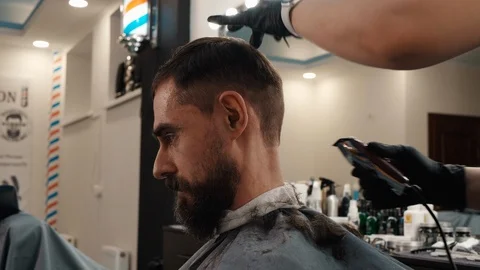 Bearded man receiving neck shave with electrical machine in barber salon Video stock 125239925
