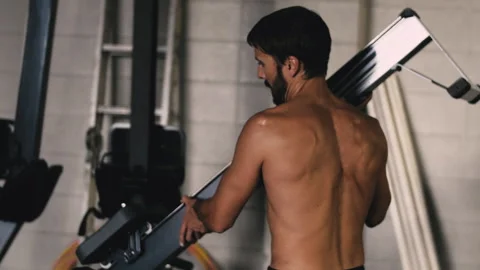 Bearded man returns bench to weight machine at local gym Stock Footage 312760308