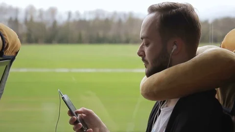 Bearded man rides bus, holding smartphone and listening to music on headphones. Stock Footage 83028013