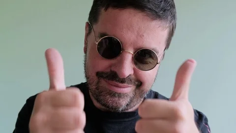 Bearded Man in round Eyeglasses Looking to Camera, ShowThump Up Stock Footage 111575549