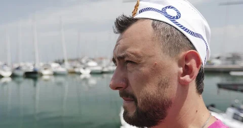 A bearded man in a sailor's cap walks along the pier. Stock Footage 118605100