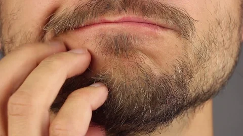 Bearded man scratching his stubble chin with fingers, front view, closeup macro Video stock 94363929