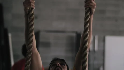 Bearded man showcases impressive dual rope climbing skills in gym Stock Footage 312765540