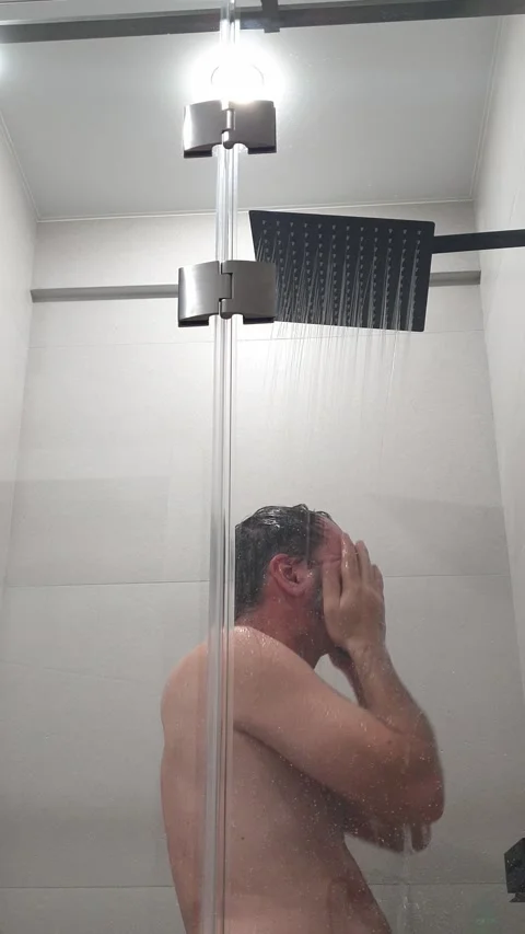 Bearded man in the shower washes under cold water and freezes Stock Footage 308532343