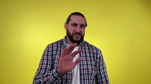 Bearded man showing refusal gesture not me sign isolated on yellow Stock Footage 236370645