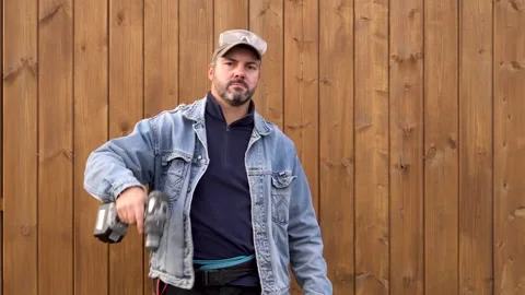 A bearded man shows a cordless drill 4K Stock-Footage 291268269