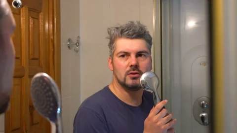 Bearded man singing in the bathroom in front of the mirror 4K Stock Footage 127720763