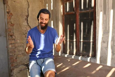 Bearded man sitting and gesticulating Stock Photos