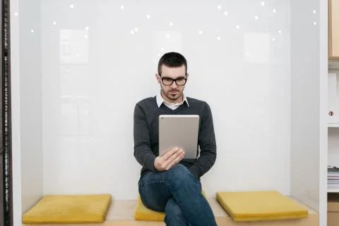 Bearded man sitting and using tablet in office Stock Photos