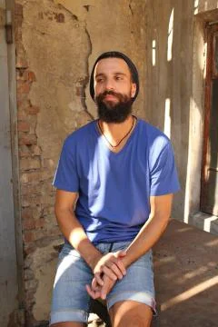 Bearded man sitting on table Stock Photos