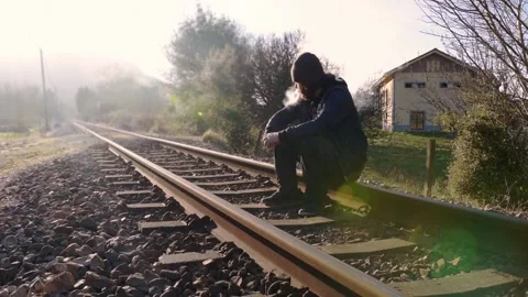 Bearded man sitting on the train track Stock Footage 146852053