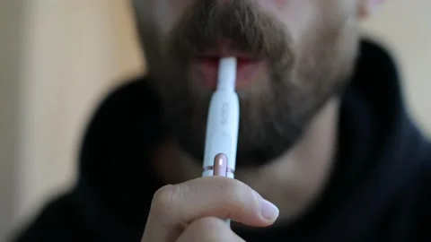 Bearded man smoke electronic cigarette IQOS. A man smokes IQOS. Stock Footage 142703010