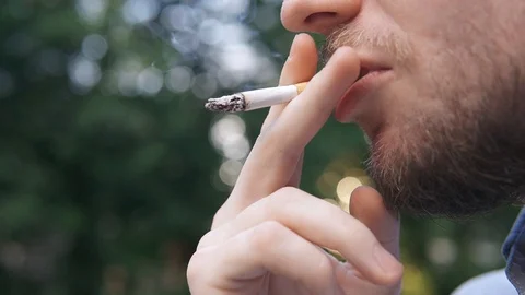 Bearded man smokes a cigarette on background evening lights city Stock Footage 129558221