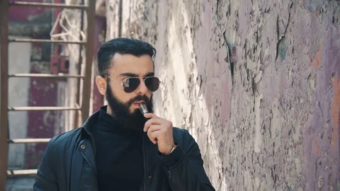 Bearded man smokes electronic cigarette Stock-Footage 74135961