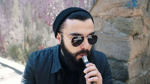 Bearded man smokes electronic cigarette Stock Footage 74138238