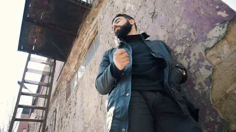 Bearded man smokes electronic cigarette Stock Footage 74139109