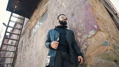 Bearded man smokes electronic cigarette Stock Footage 74139339