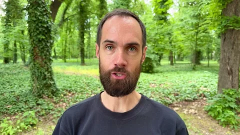 Bearded Man Speaking to Camera in Lush Green Subotica Park Vídeos de archivo 336178230