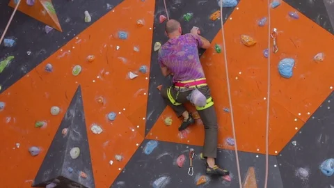 Bearded man with special equipment climbing on wall. Male training on climb wall Stock Footage