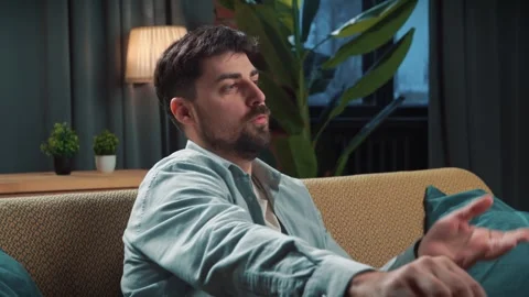 Bearded man spending time at home with fast food delivery, sits on couch Stock Footage 305483911