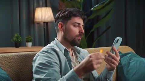 Bearded man spending time at home with fast food delivery, sits on couch Stock Footage 305484278