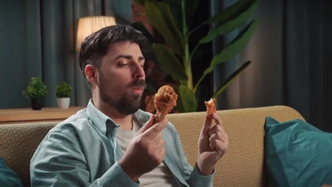 Bearded man spending time at home with fast food delivery, sits on couch Stock Footage 305484621