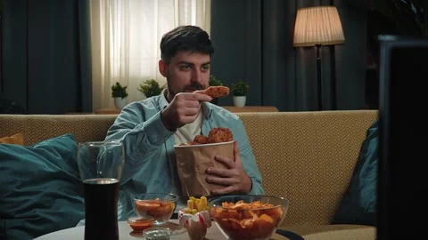 Bearded man spending time at home with fast food delivery, sits on couch Stock Footage 305491543