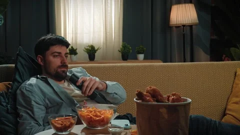 Bearded man spending time at home with fast food delivery, lays on couch Stock Footage 305493649