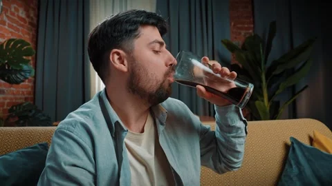 Bearded man spending time at home with fast food delivery, sits on couch and Stock Footage 305495391