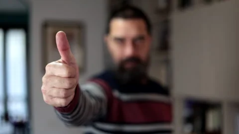 Bearded man standing with serious expression and finger thumb up at home. Stock Footage 266303214