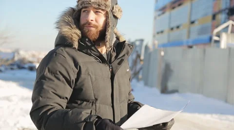 Bearded man stands on cold winter street and keeps plan in his arms 스톡 동영상 65227513