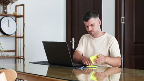 Bearded man sticks a note on his laptop. Stock Footage 314006555