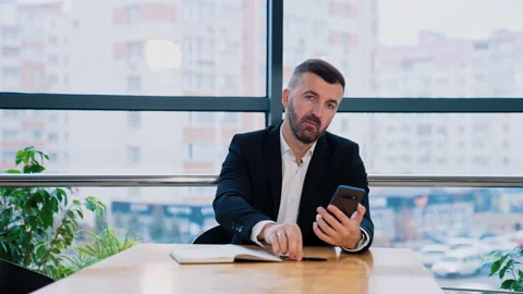 Bearded man in suit sits at the desk in his office.  Stock-Footage 196592753