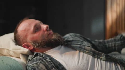 Bearded man takes comfortable pose on sofa to take rest Stock Footage 237709608
