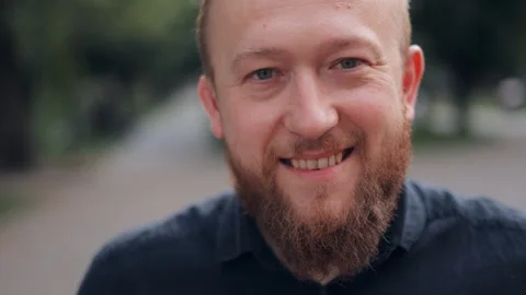 Bearded man, taking off his glasses and looking at the camera smiling Stock Footage 244245898