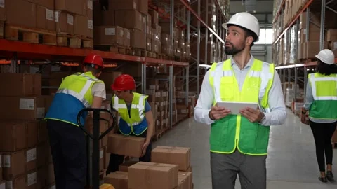 Bearded man taking inventory of goods in warehouse Stock Footage 161950100