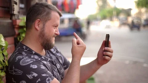 Bearded man talking on the phone and chatting in a cafe on the street. bearded Stock Footage 103922004