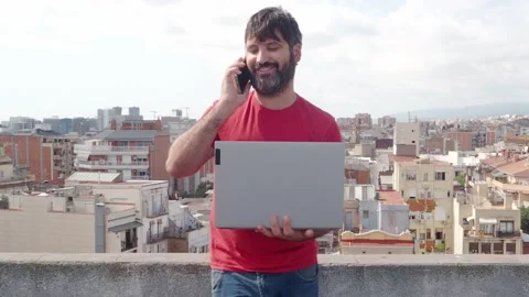 Bearded man talking on smartphone and his laptop Stock Footage 139751589