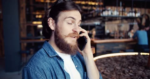 Bearded Man Talking on Smartphone in Cafe 库存影片 116316153