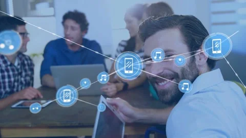 Bearded man tapping tablet starting phone and music nodes spreading over table Stock Footage 334114361