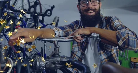 Bearded man testing brake tension by pulling lever in bike shop while gold stars Stock Footage 326096243